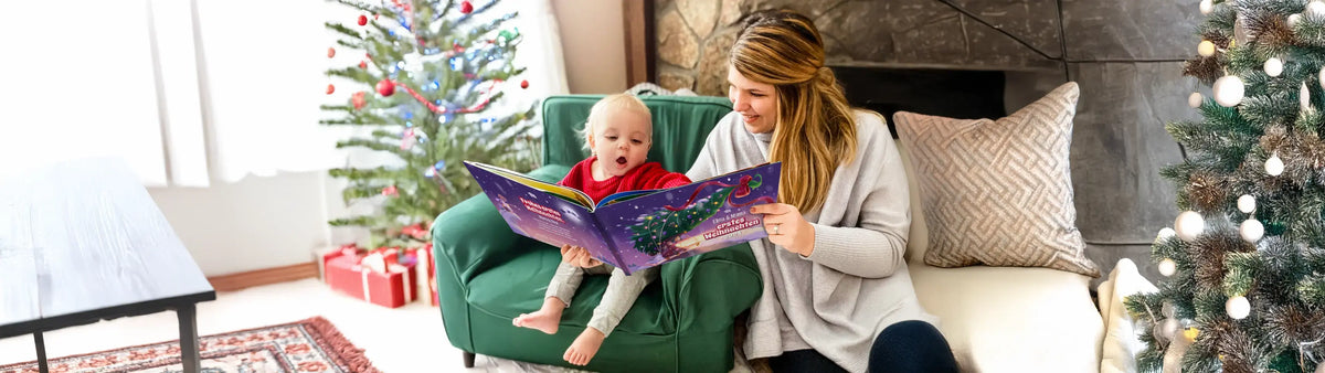 Mama und Baby lesen ein Buch, Weihnachtsbaum im Hintergrund
