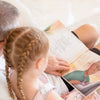 Ein Großvater und Enkeltochter blättern in ihrem personalisierten Buch für Opas, das beste Geschenk für jeden Opa. 
