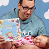 Vater und Tochter lesen gemeinsam ein personalisiertes Buch über die nächtliche Routine, das auch ein lustiges Bauernhofbuch ist.	
