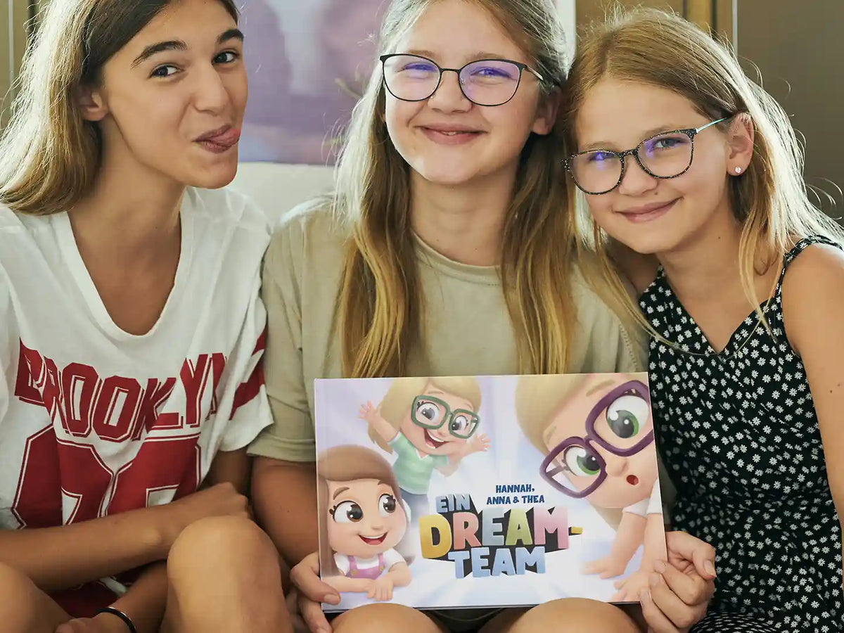 Drei Schwestern zeigen ihr personalisiertes Abenteuerbuch von Hurra Helden. 