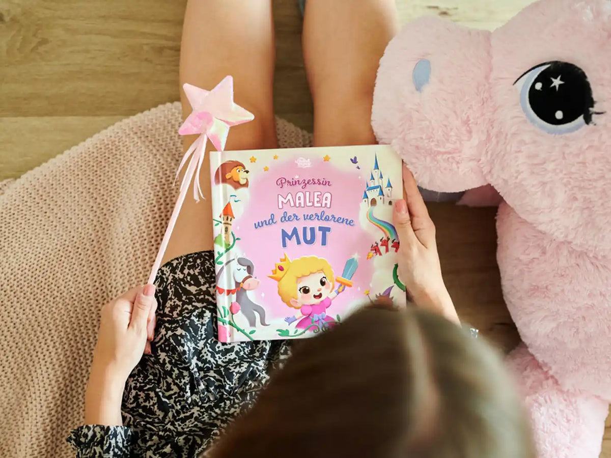 Ein Mädchen hält das neue personalisierte Buch über eine Prinzessin, die ihren Mut gefunden hat.		