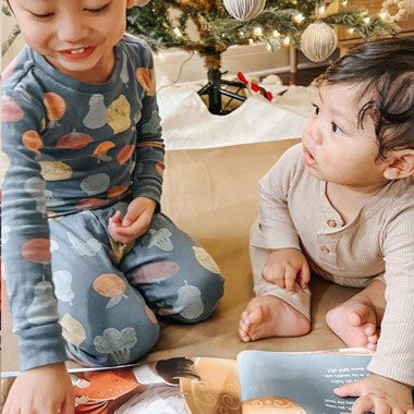 Zwei kleine Geschwister haben zu Weihnachten ein personalisiertes Weihnachtsbuch von Hurra Helden geschenkt bekommen.