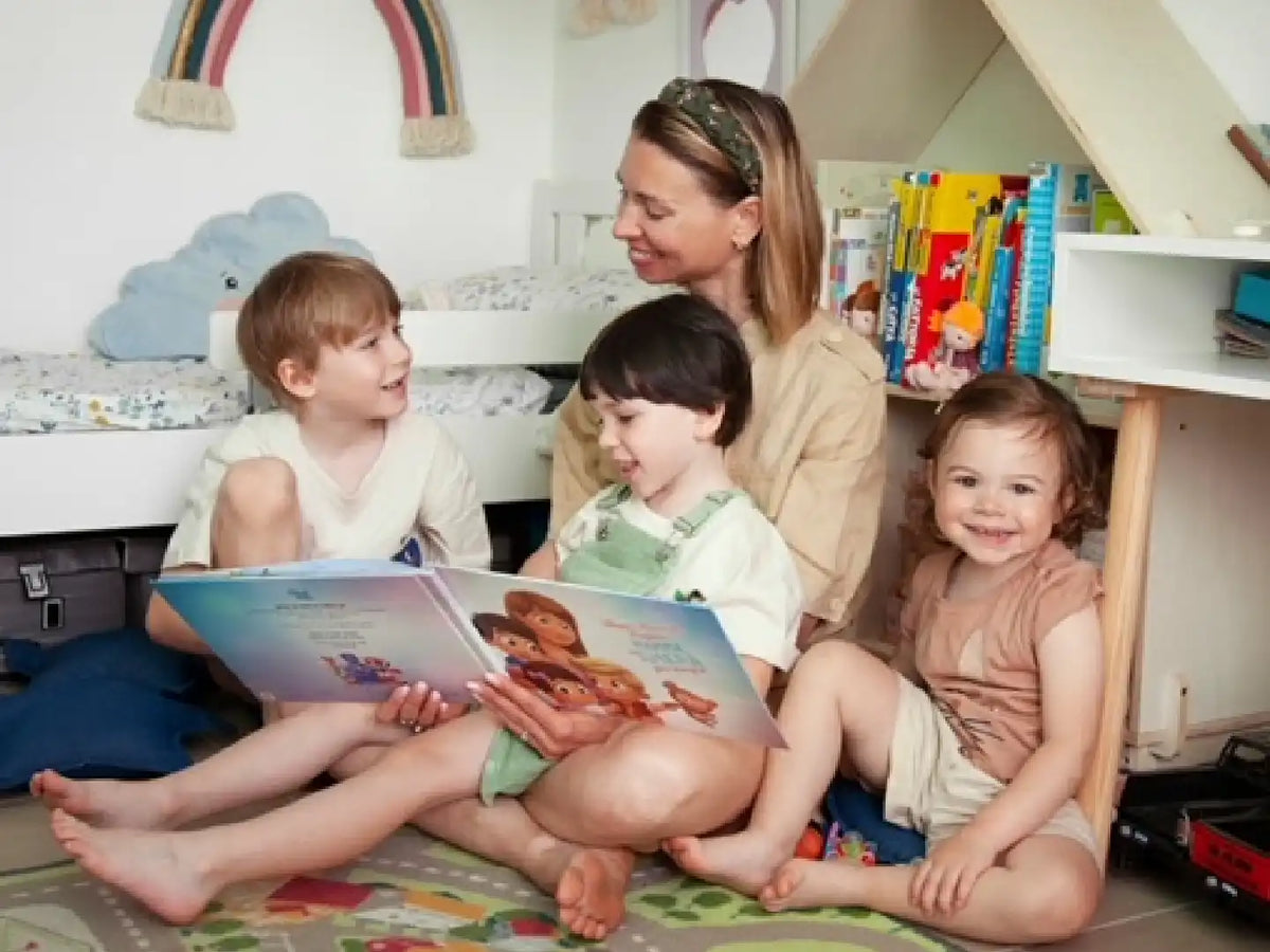 Eine lächelnde Mutter und ihre Kinder freuen sich über ihr personalisiertes Buch für mehr Kinder.