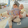 Süße Kinder posieren neben ihrem personalisierten Babybuch, das ein tolles Geschenk für neue Familien ist.	