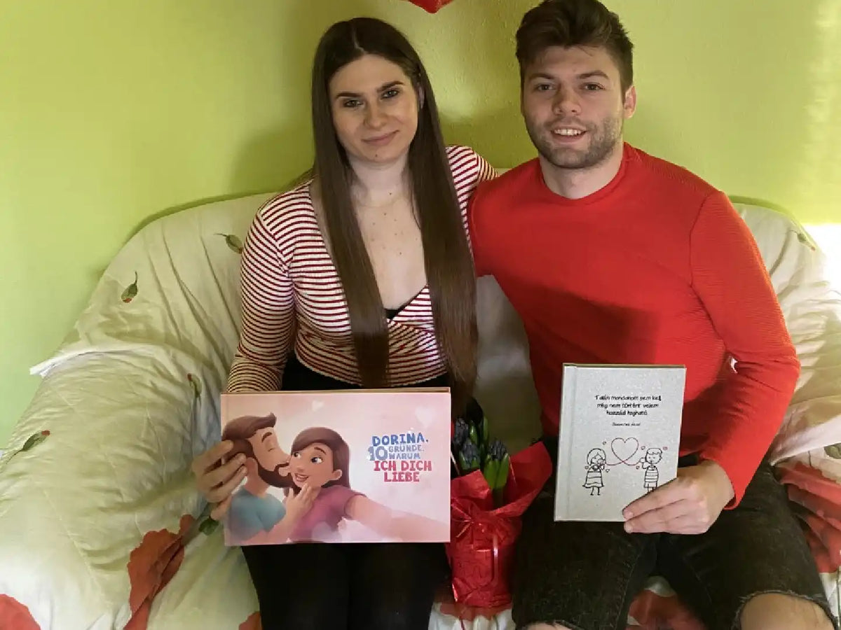 Glückliche Kunden halten ihr personalisiertes Buch für Paare von Hurra Helden.			