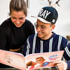 Dieses Paar hat das richtige Geschenk für ihren Partner zum Valentinstag gefunden: das personalisierte Buch Hurra Helden.			
