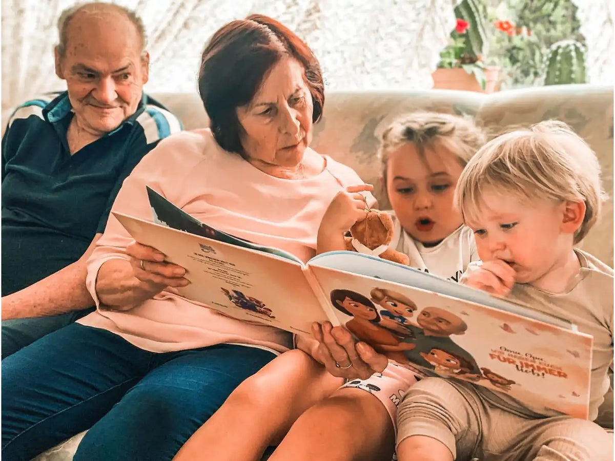 Glückliche Enkelkinder und Großeltern mit ihrem personalisierten Buch für Omas und Opas. 