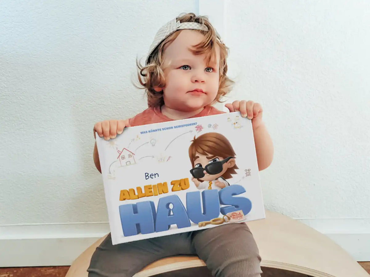 Ben hält sein personalisiertes Buch „River ist allein zu Hause“ und freut sich auf schelmische Dinge.