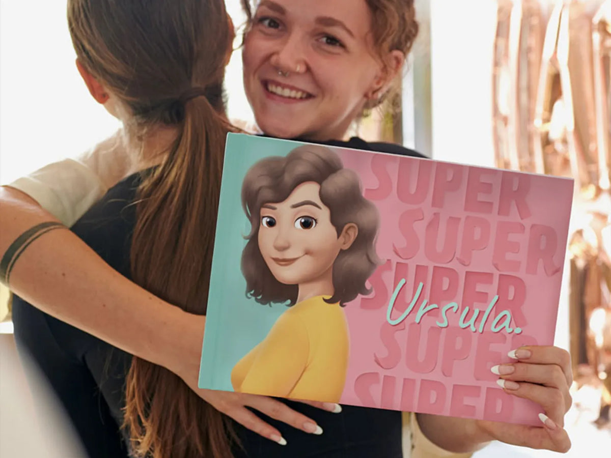 Ein lächelndes Mädchen mit ihrem neuen personalisierten Buch, das ein Geschenk ihrer Freundin war.